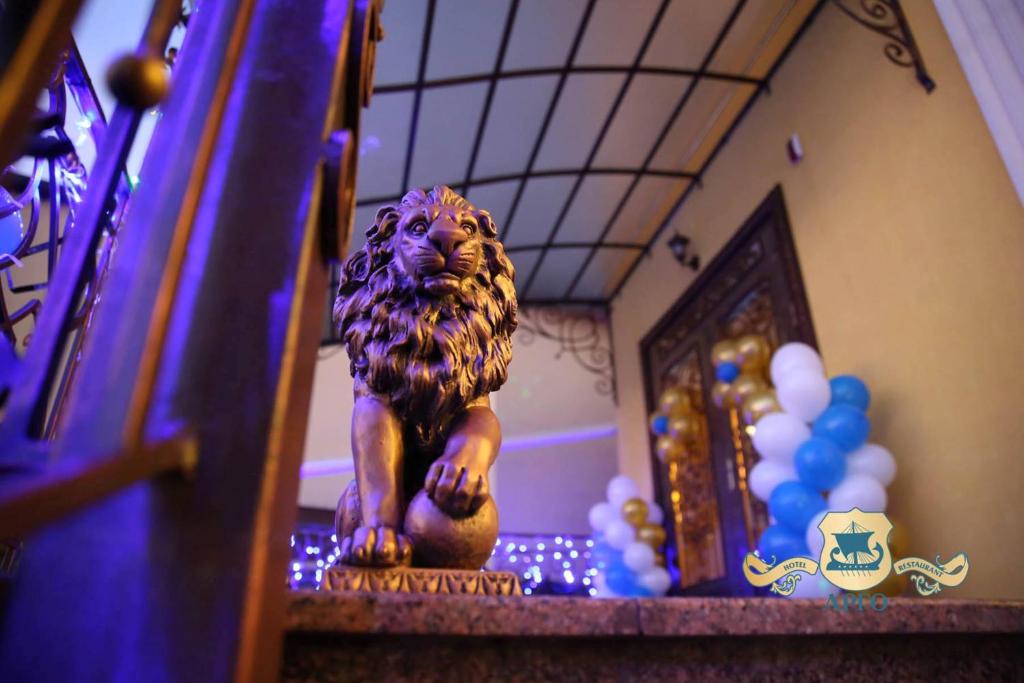 una estatua de un león sentado en una pelota en una escalera en Argo, en Leópolis