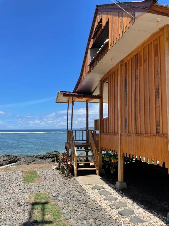 a building on the beach with the ocean in the background at Kertasari Golden House Homestay in Pulau Sarang