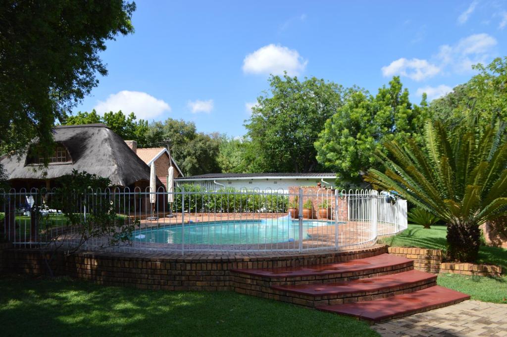 a swimming pool with a fence and stairs around it at Franka Guesthouse in Rustenburg