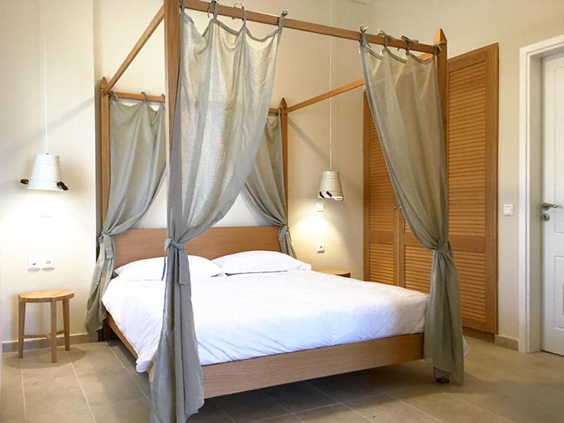 Schlafzimmer mit einem Himmelbett und Moskitonetzen in der Unterkunft Aria Monte Villas in Raches