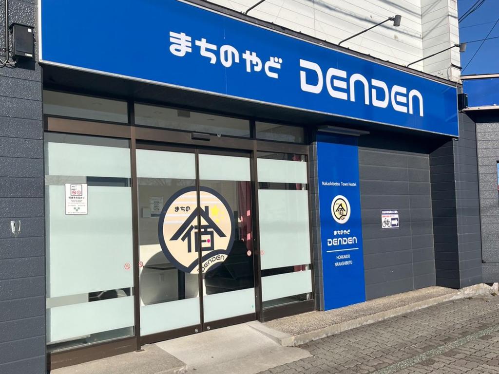 中标津町Tabist machinoyado denden的登哥伦布商店门上的标志