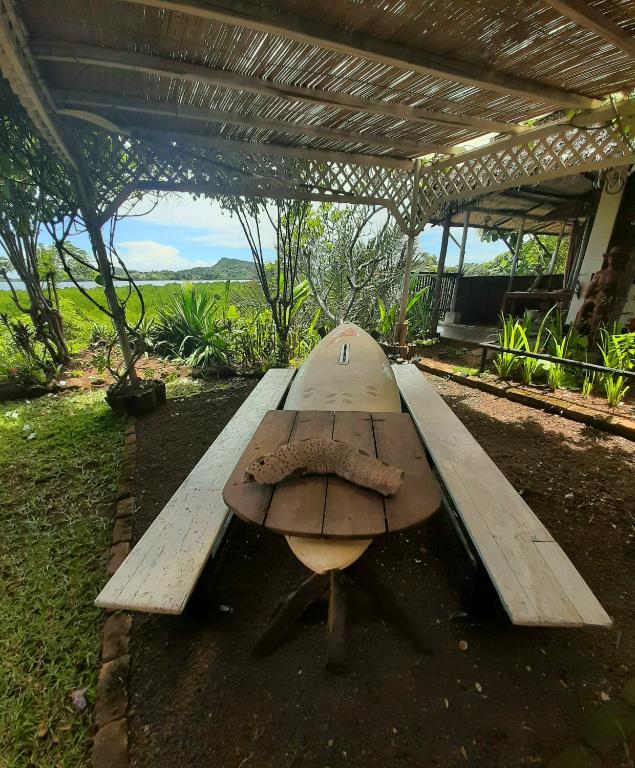a surfboard sitting on top of a wooden bench at La Table d Alexandre Gîte de charme entre mangrove et mer in Hell-Ville