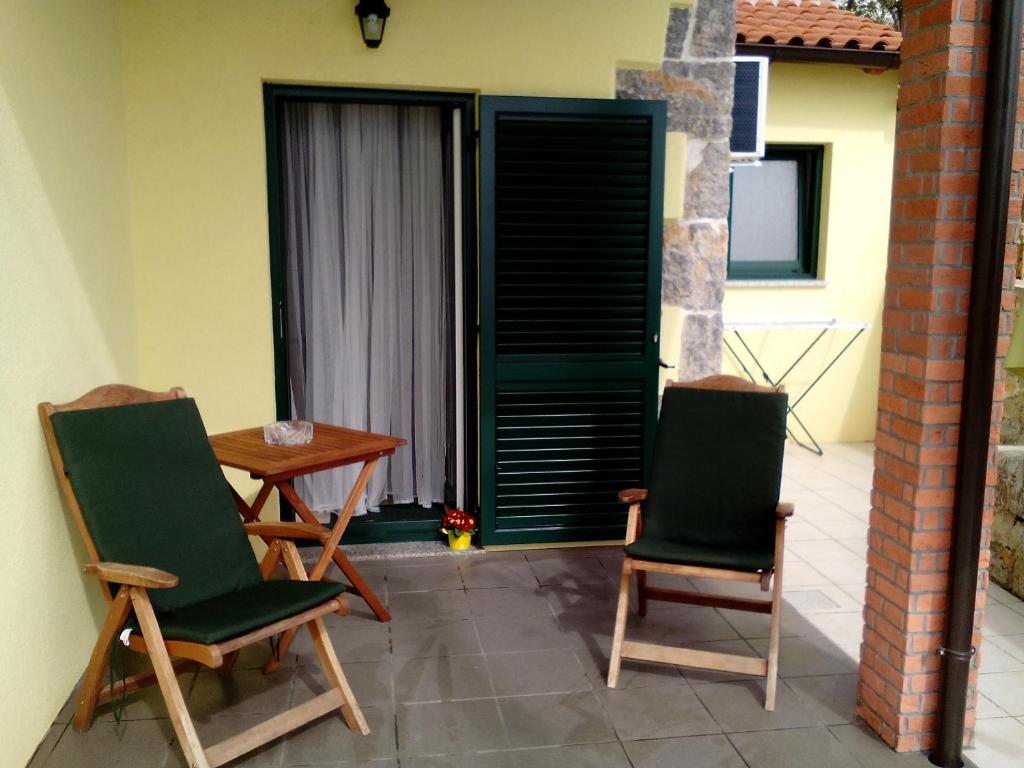Duas cadeiras e uma mesa num pátio em Studio Laura em Ičići