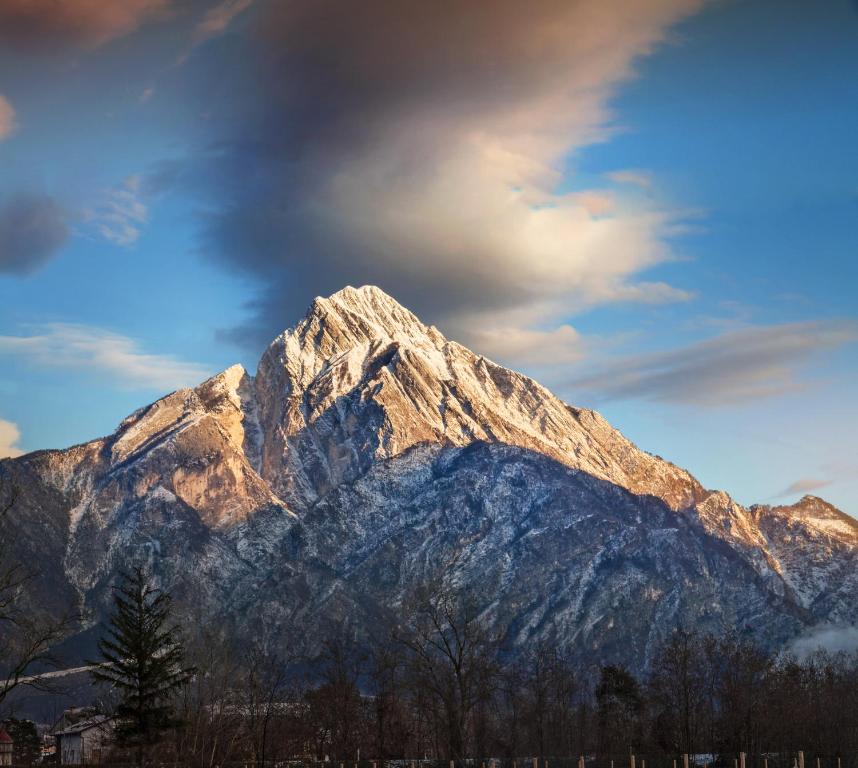 a snow covered mountain with a cloudy sky at Albergo Diffuso Tolmezzo in Tolmezzo