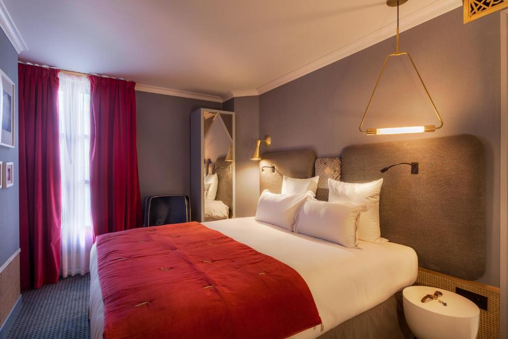 a bedroom with a large bed with a red blanket at Handsome Hotel in Paris