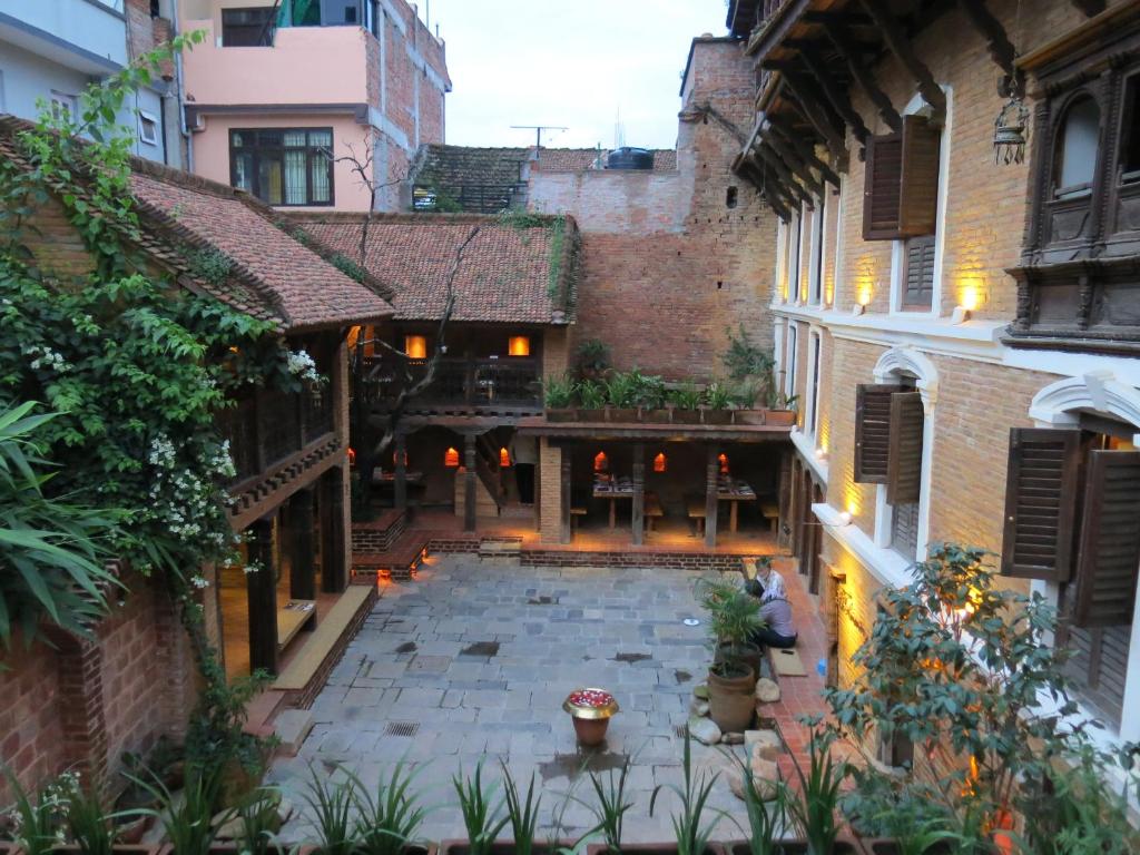 une cour vide dans un vieux bâtiment avec des bâtiments dans l'établissement The Inn Patan, à Pātan
