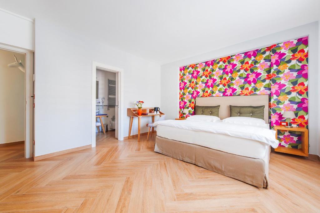 een slaapkamer met een groot bed en een kleurrijke muur bij B&B Verù in Sorrento