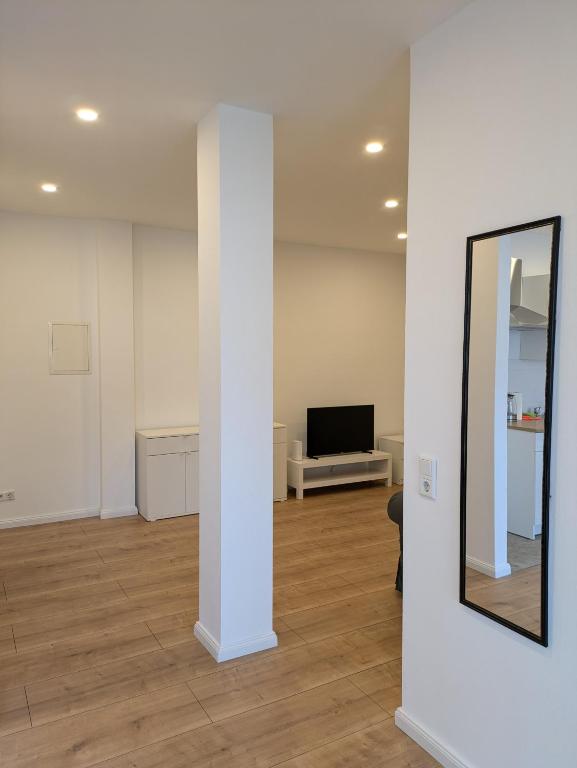 a room with a white column and a mirror at interaktiv Appartements in Ratingen - Düsseldorferstrasse in Ratingen
