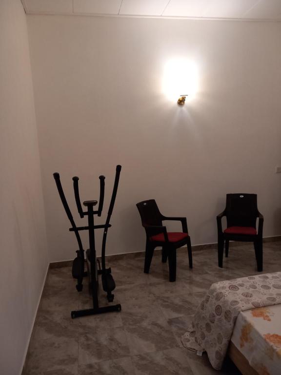 Habitación con 2 sillas, 1 cama y luz en Forrthuna Mio Villa, en Negombo