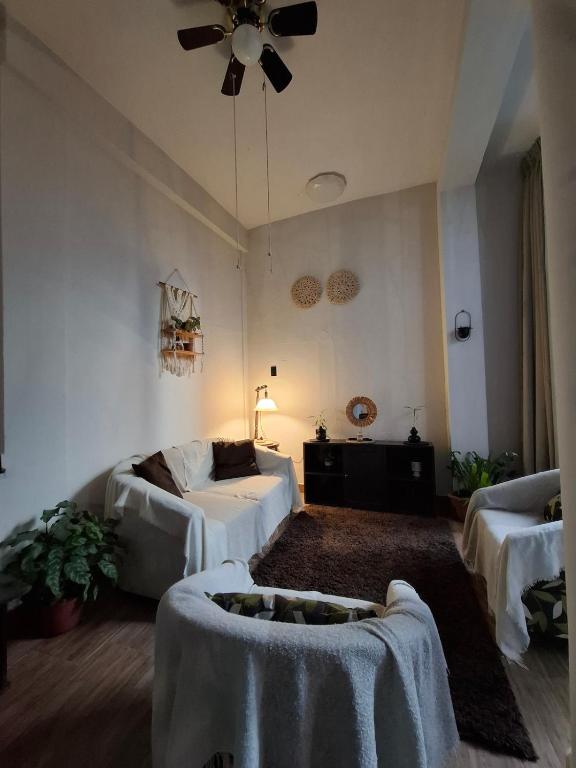 a living room with two beds and a ceiling fan at Garden House in Tarapoto