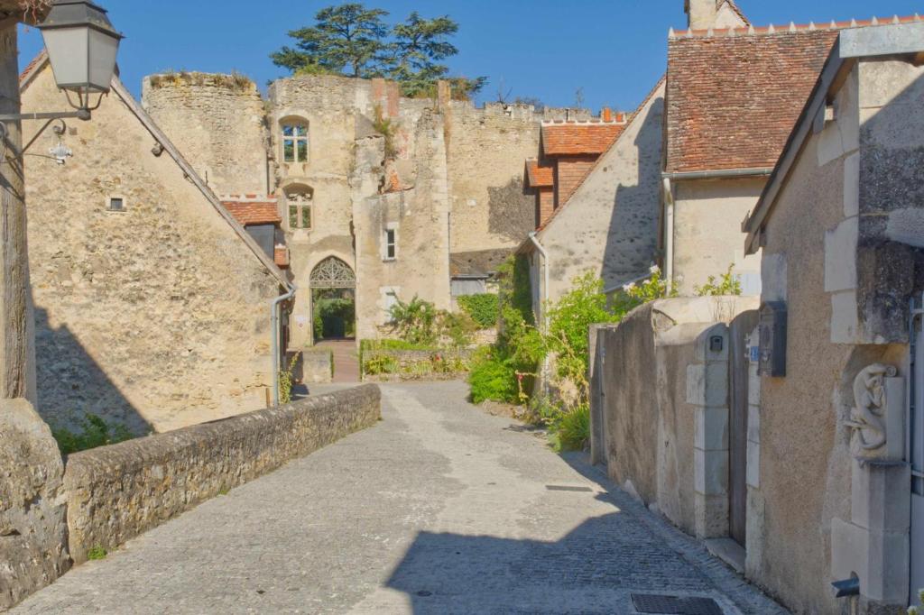 une ruelle dans une ville médiévale avec un château dans l'établissement Le trésor de grand-mére, à Montrésor