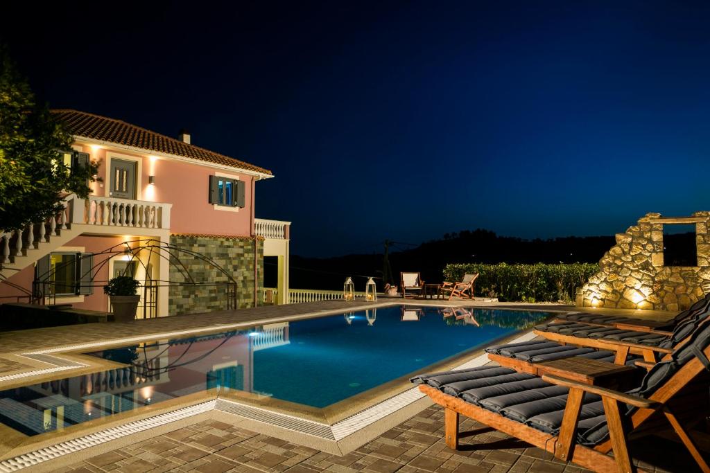 a villa with a swimming pool at night at Villa Athinais in Lixouri