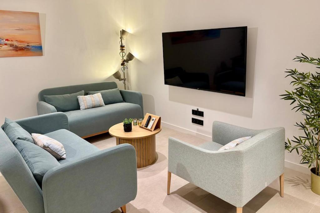 ein Wohnzimmer mit zwei Sofas und einem Fernseher in der Unterkunft Family Home Valencia in Aldaia