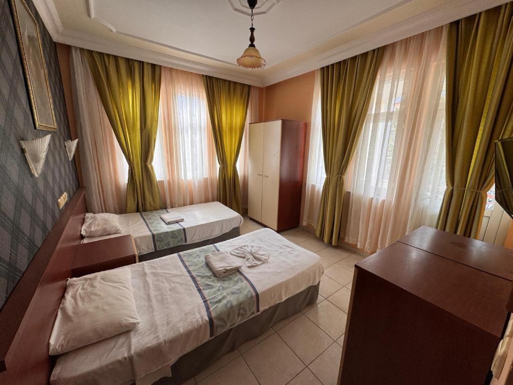 a hotel room with two beds and a desk at BEGONYA HOTEL KEMER-All İnclisuve in Antalya