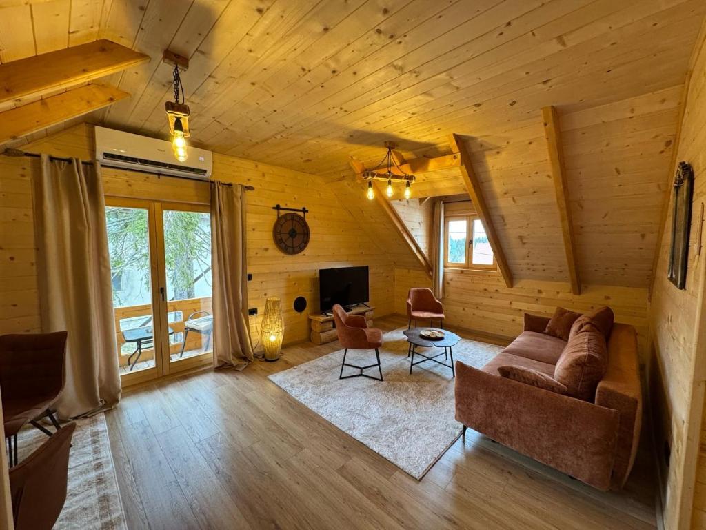a living room with a couch and a tv at Brvnara La Forêt in Žabljak