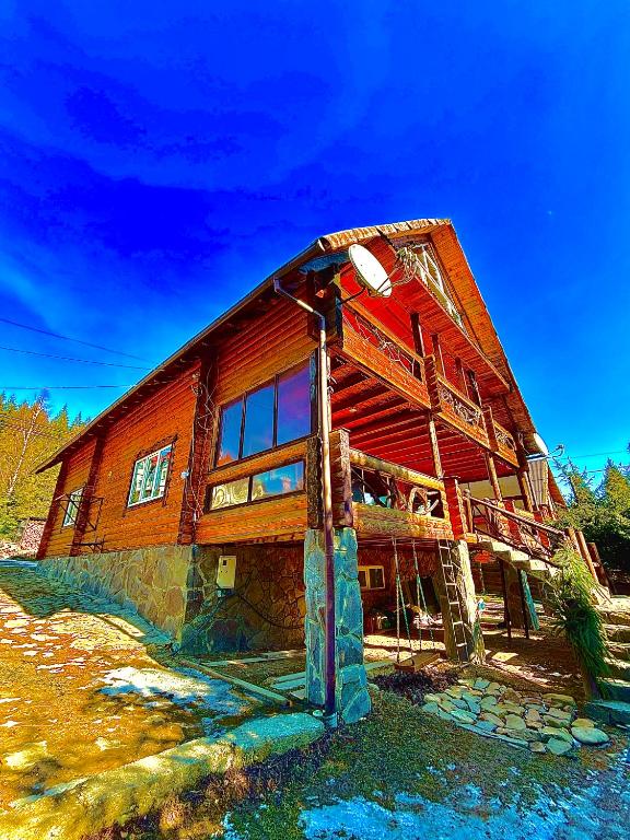 a large wooden barn with a blue sky in the background at Ранчо в Карпатах in Bukovel