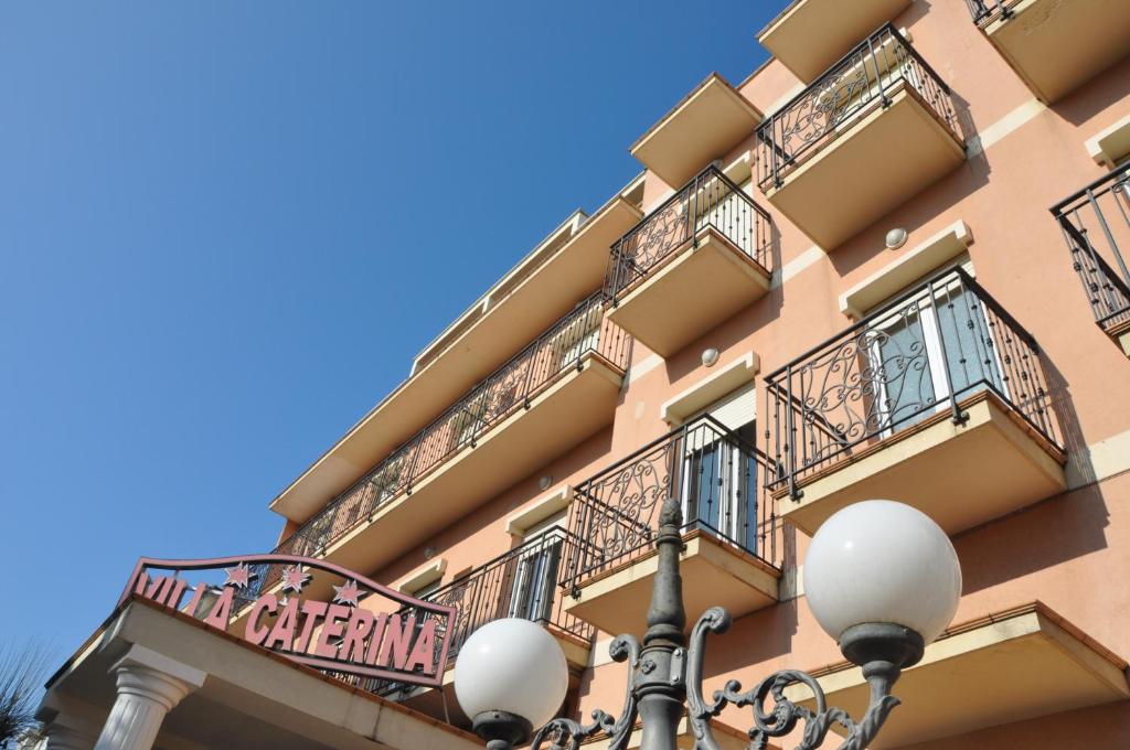un edificio con balcones y luz de la calle en Hotel Villa Caterina, en Rímini