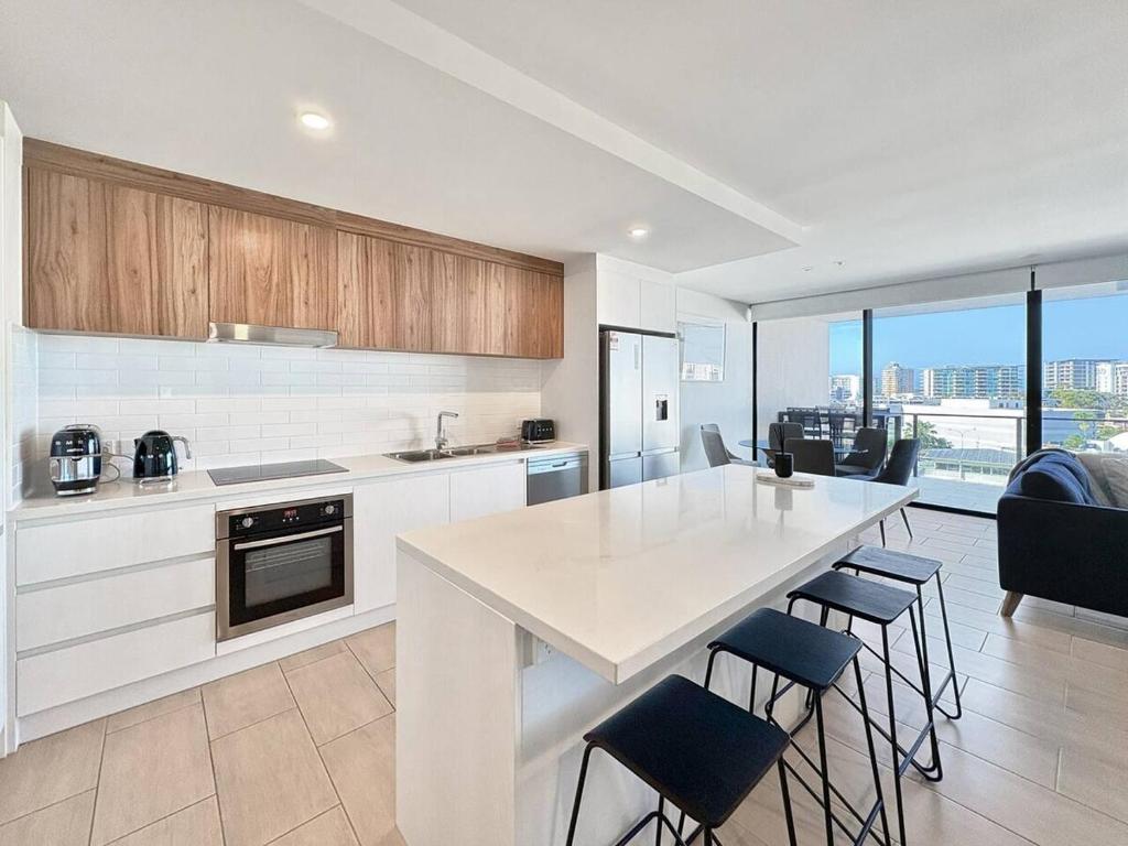 a kitchen with a table and some chairs in it at Luxury Maroochydore Apartment in Maroochydore