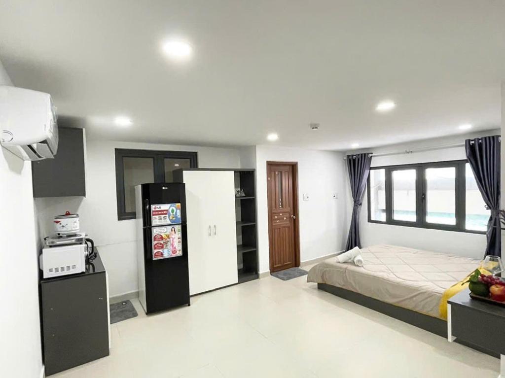 胡志明市Homey Haven Sư Vạn Hạnh的一间卧室配有床和冰箱