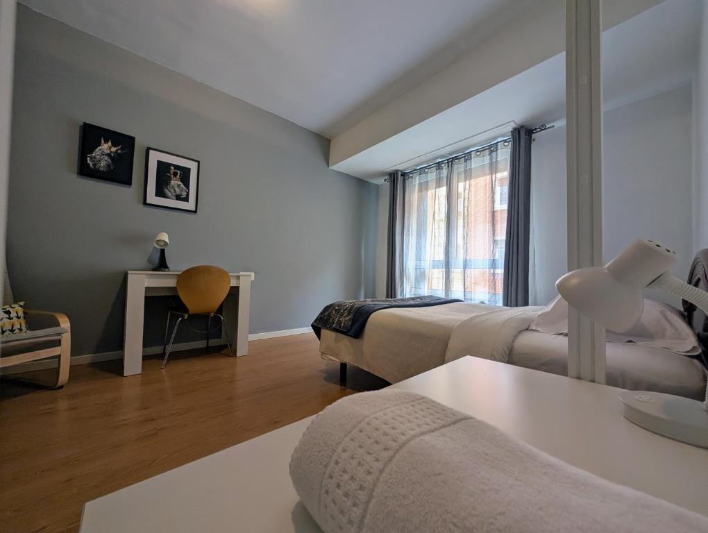 a hotel room with two beds and a window at Gasteiz Etxea l in Vitoria-Gasteiz