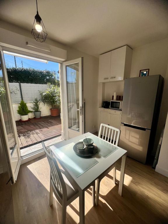 une cuisine et une salle à manger avec une table et un réfrigérateur dans l'établissement Magnifique 2P à IGNY proche Saclay, Massy, Versailles, Paris, à Igny