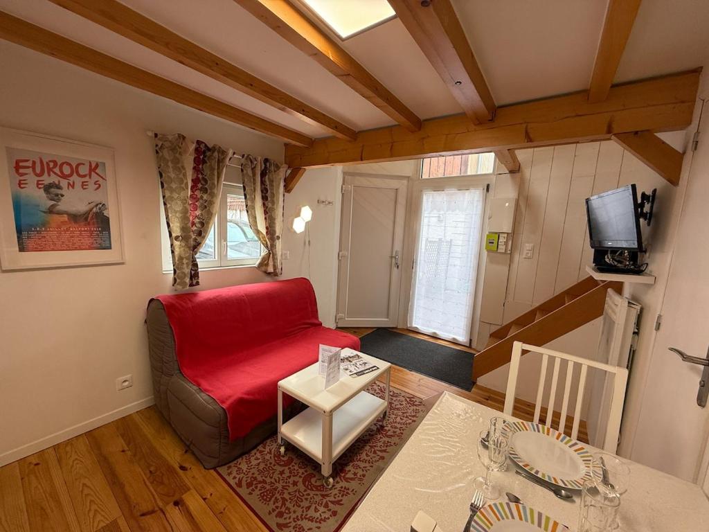 un salon avec un canapé rouge et une table dans l'établissement Escale Belfortaine - Dépendance au calme, à Belfort