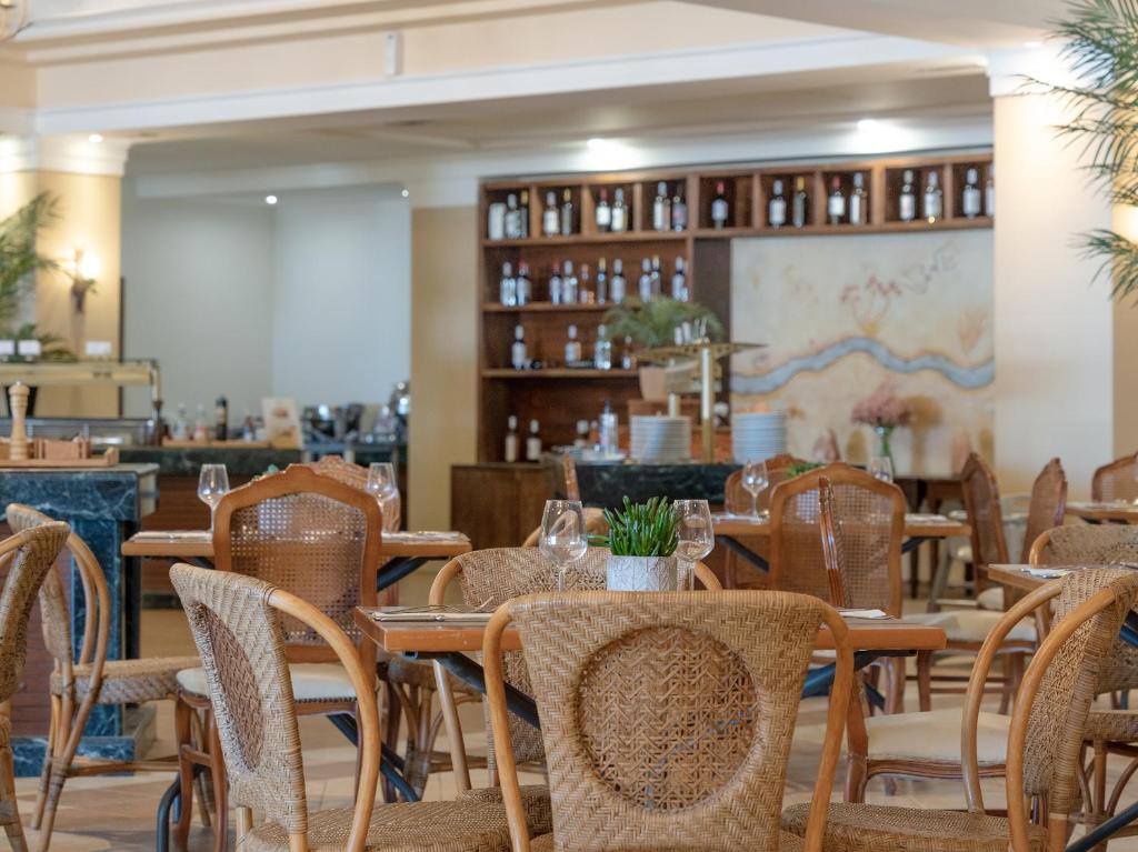 a dining room with tables and chairs in a restaurant at Grecotel Marine Palace & Aqua Park in Panormos Rethymno