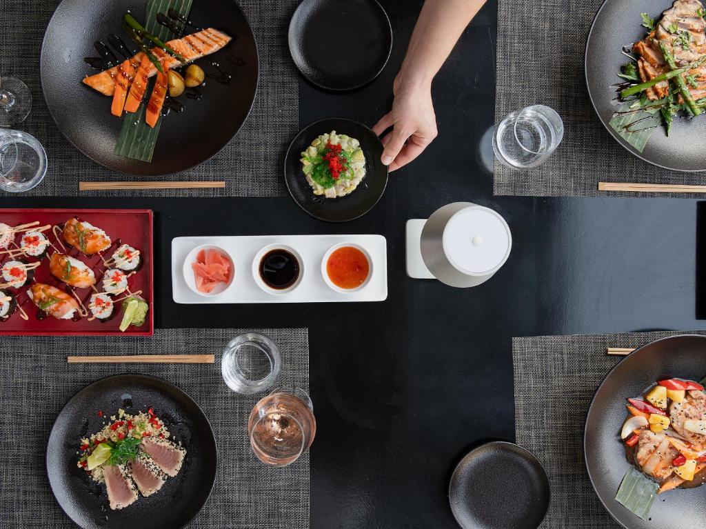 a black table with plates of food on it at Grecotel Marine Palace & Aqua Park in Panormos Rethymno