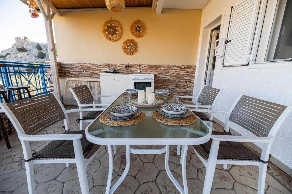 Biały stół i krzesła na patio w obiekcie Aperanto Galazio Apartment w mieście Archangelos