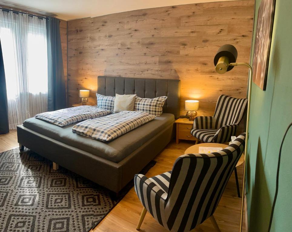 a bedroom with a bed and a couch and chairs at Pension Trautheim - Am Stadtpark in Bad Harzburg