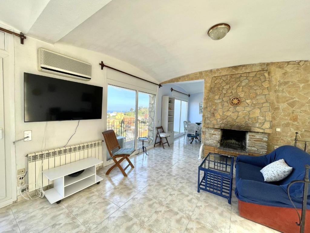 a living room with a fireplace and a tv at casa 7 pins in Begur