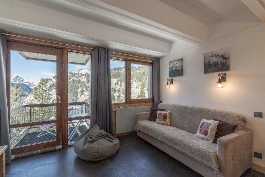 un salon avec un canapé et une grande fenêtre dans l'établissement Flaine Appt H3, à Arâches-la-Frasse