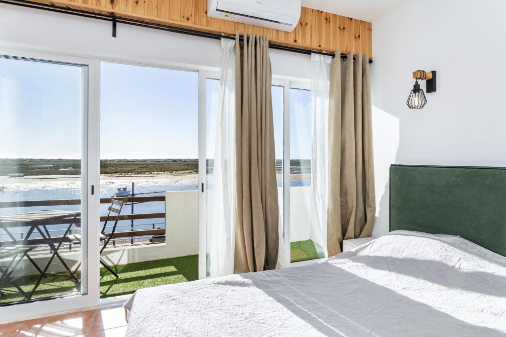 a bedroom with a bed and a view of the ocean at Cabanas de Tavira - T1 in Cabanas de Tavira