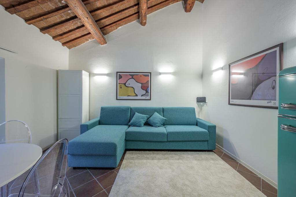 ein Wohnzimmer mit einem blauen Sofa in einem Zimmer in der Unterkunft Piazza Ariostea Apartment in Ferrara