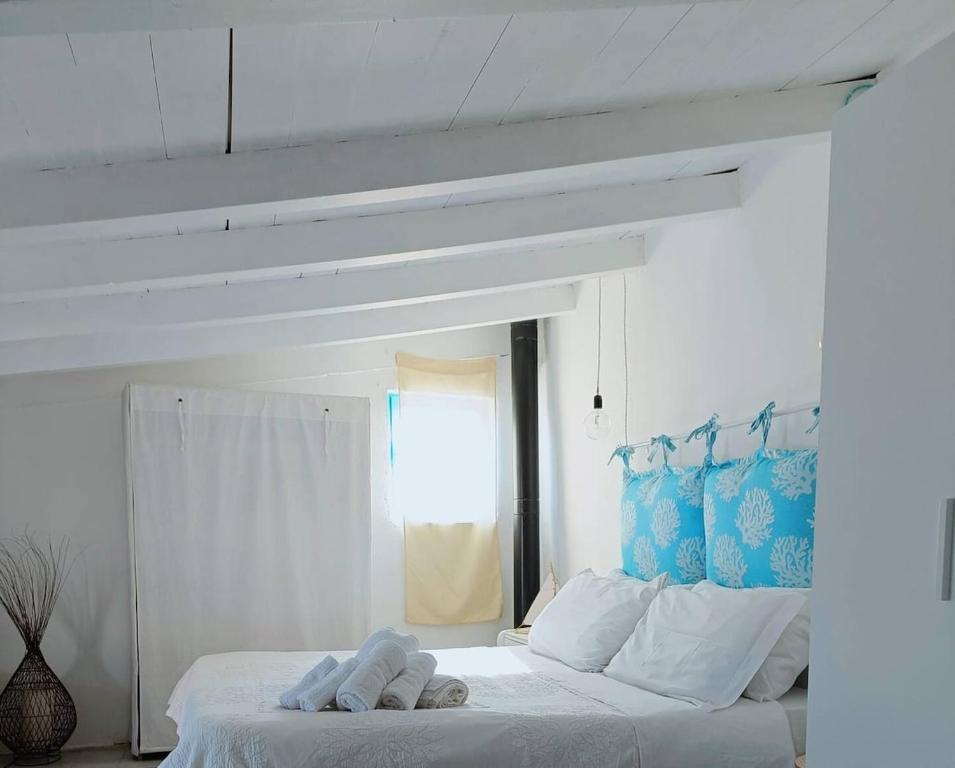 een slaapkamer met een wit bed met handdoeken erop bij Nura's - Il Balcone sui Tetti in Alghero