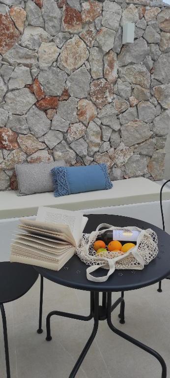 a table with a bowl of oranges on a wall at Casa Stergia - Village Project in Psinthos