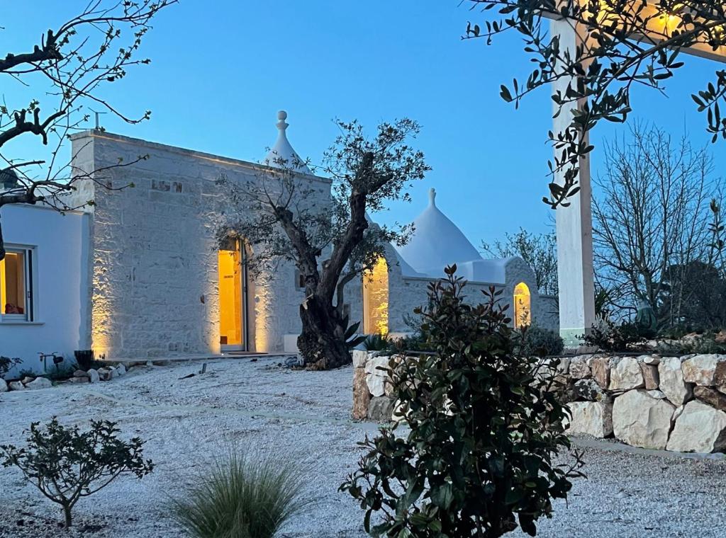 a white house with a tree in front of it at Trulli DaMì in Ceglie Messapica