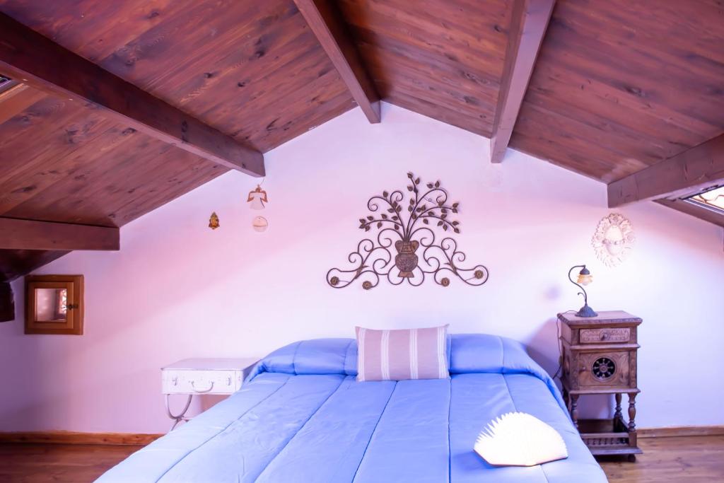 een slaapkamer met een blauw bed en houten plafonds bij La Cambusa Apartment in Alghero