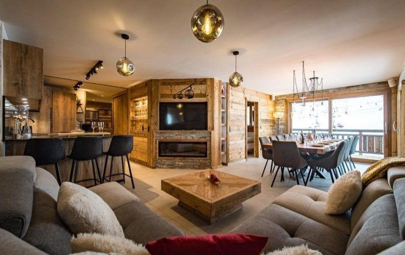 un salon avec un canapé et une table et une cuisine dans l'établissement La Loge Des Chats, à La Toussuire