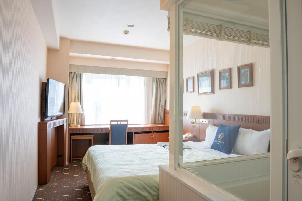 a hotel room with a bed and a desk and a mirror at Boston Plaza Kusatsu Biwa Lake - Vacation STAY 15410v in Kusatsu