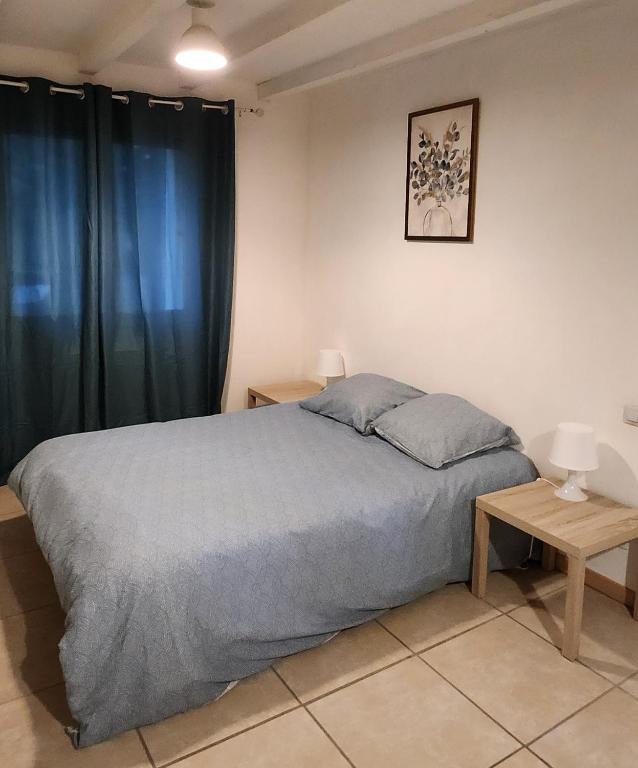 a bedroom with a large bed and a table at Maisonnette Provençale in Le Thor