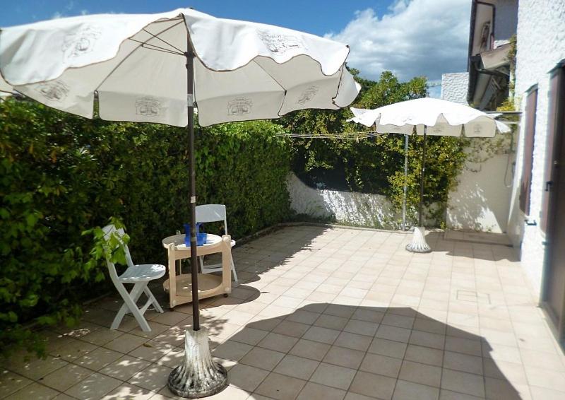 a patio with an umbrella and a table and chairs at Trilo Simonetta a Marcelli, con aria condizionata e posto auto in Marcelli