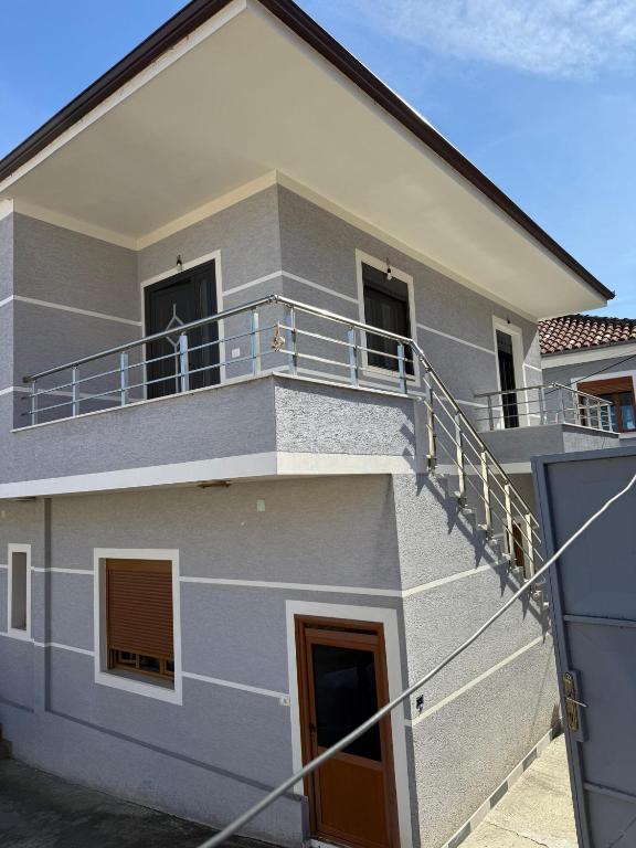 a house with a balcony with a dog on it at Stormi's Apartament in Pogradec