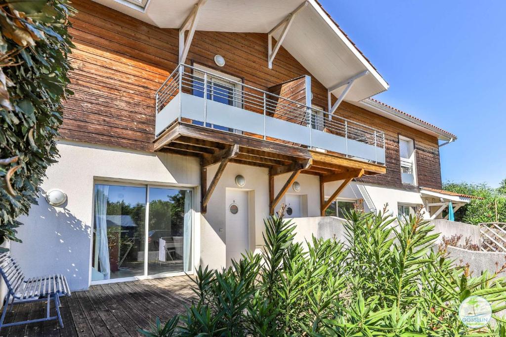 Biscarrosse bourg Duplex proche commerces 6 couchages في بيسكاروس: منزل به شرفة على جانبه
