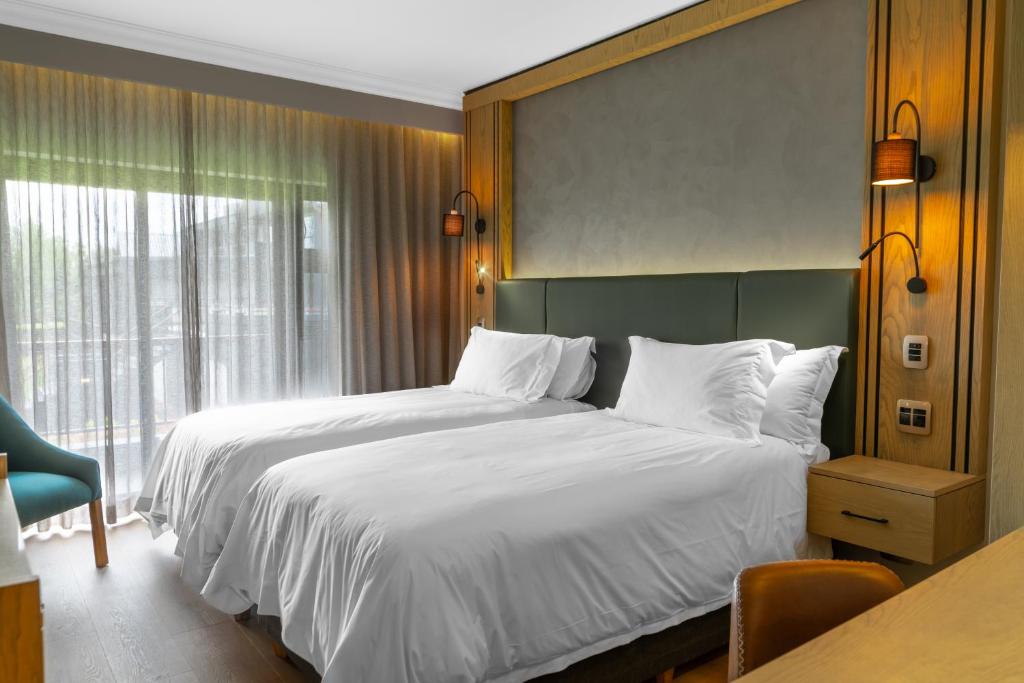 a hotel room with two beds and a window at Emerald Resort & Casino in Vanderbijlpark