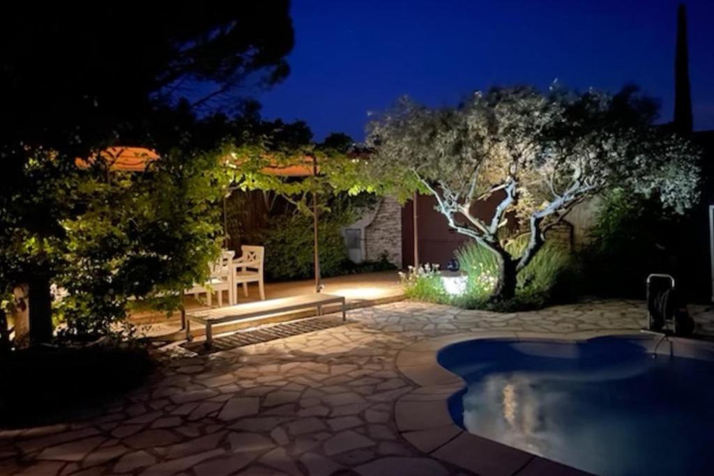 - un jardin de nuit avec une table et une chaise dans l'établissement La Maison Rose, à LʼIsle-sur-la-Sorgue
