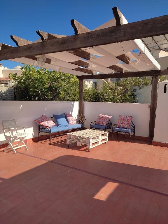 Un patio con dos sofás y una mesa y sillas. en Apto Pueblo Luna, en Mojácar