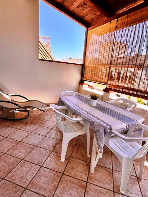 a table and chairs in a room with a window at House on the beach in Lido Marini