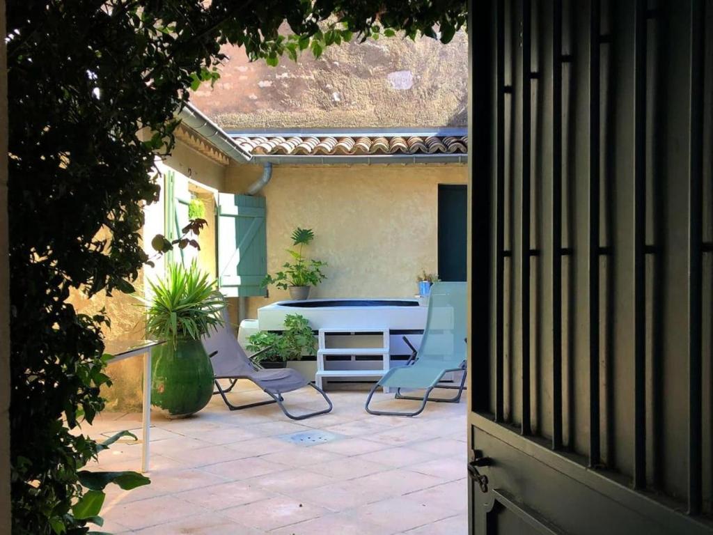 une cour avec des chaises et une table. dans l'établissement Maison de centre ville avec jacuzzi, à Nîmes