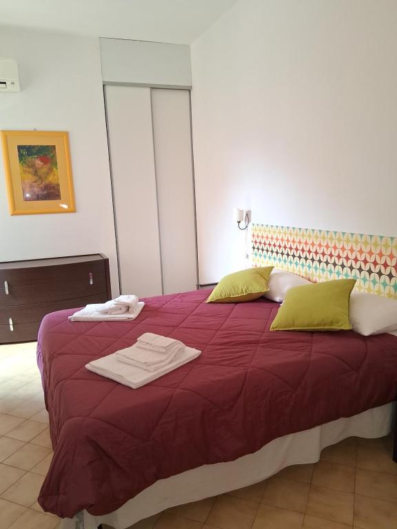 a bedroom with a purple bed with towels on it at Appartamento Silvana in Grosseto